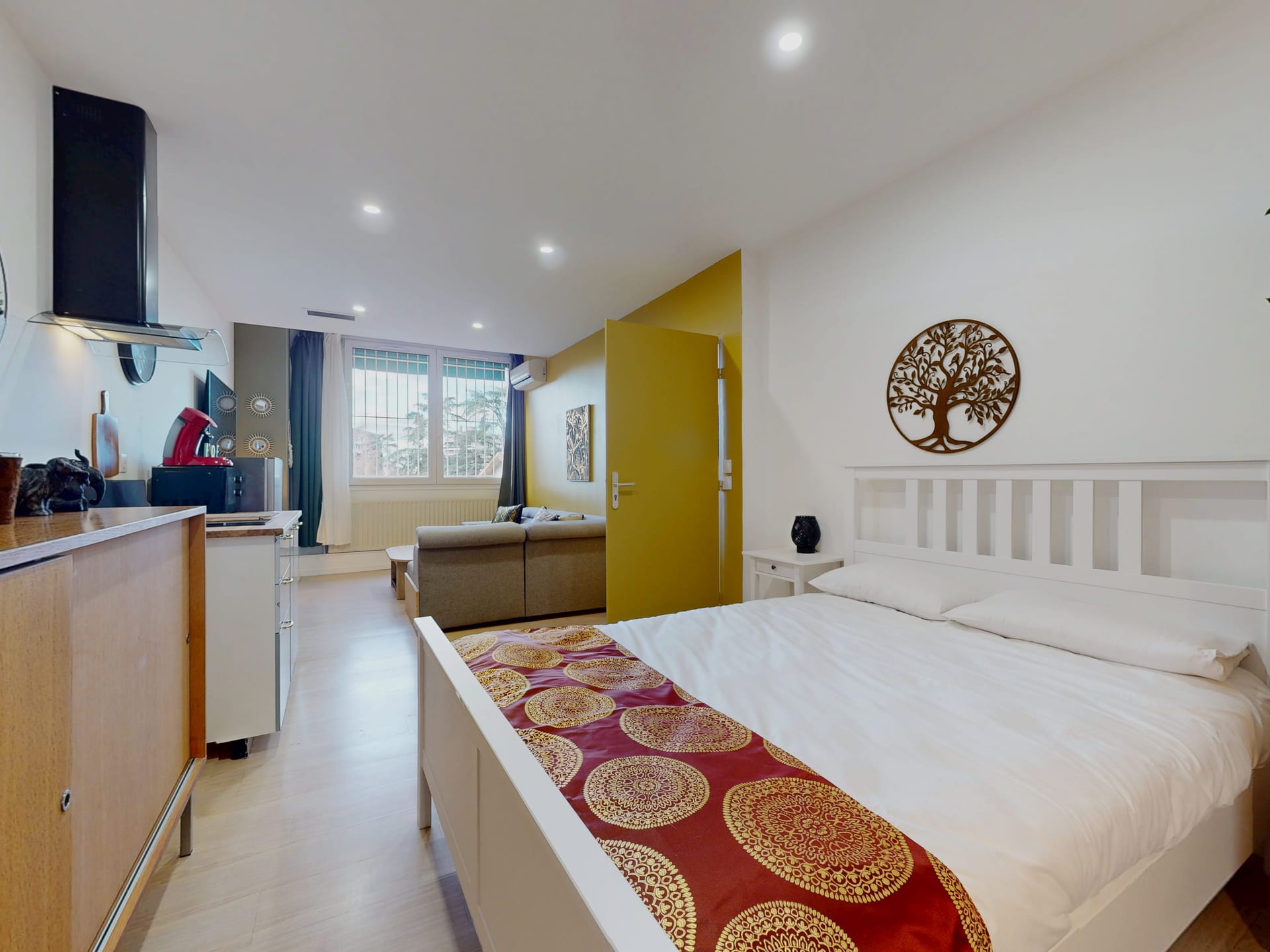 Grande chambre avec lit double, coin salon et kitchenette privative