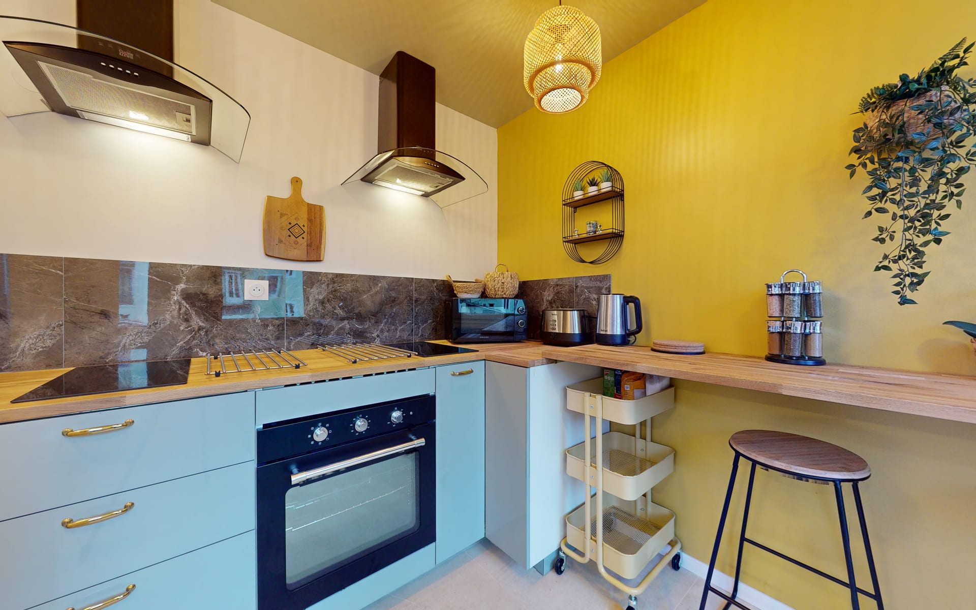 Plan de travail de la cuisine avec plaque de cuisson, four, hottes et rangements hauts
