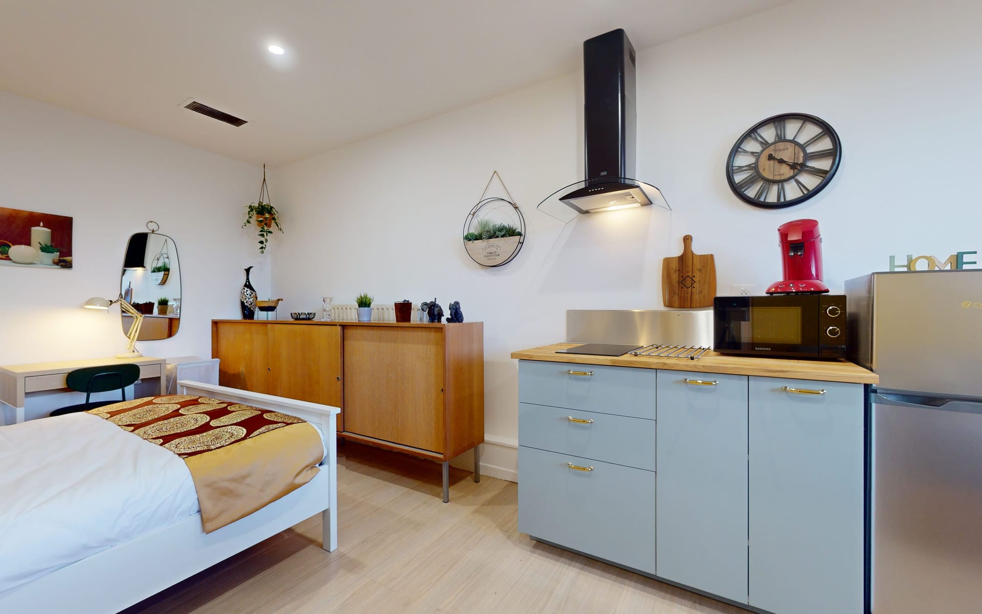 Kitchenette privative d'une chambre : plaque, four, hotte et réfrigérateur