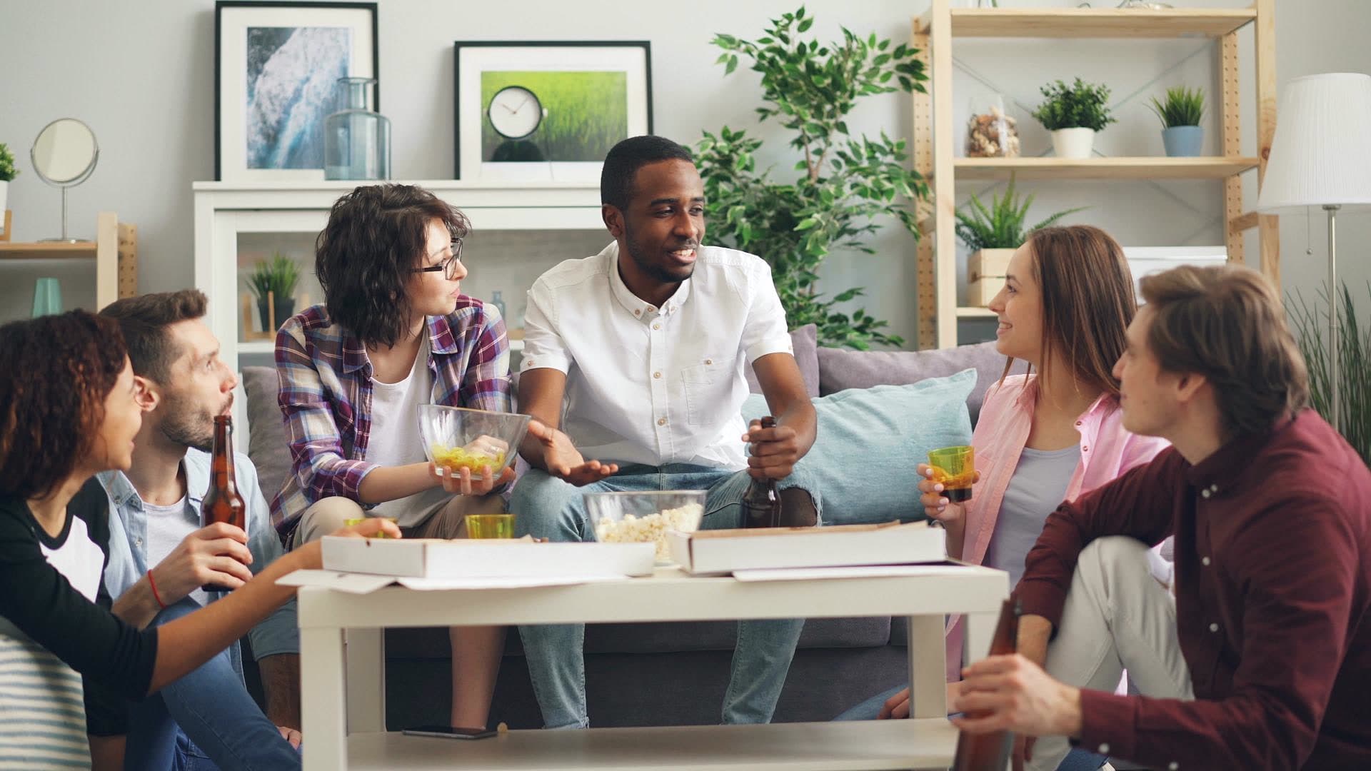 Salon commun d'une colocation meublée avec canapé, table basse et grandes fenêtres
