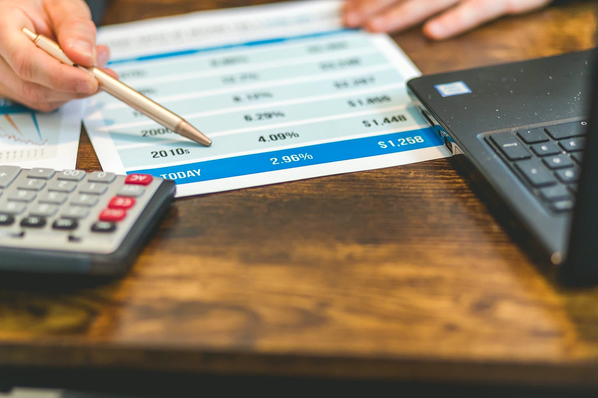 Calculatrice, relevé de revenus locatifs et trousseau de clés sur un plan de travail clair