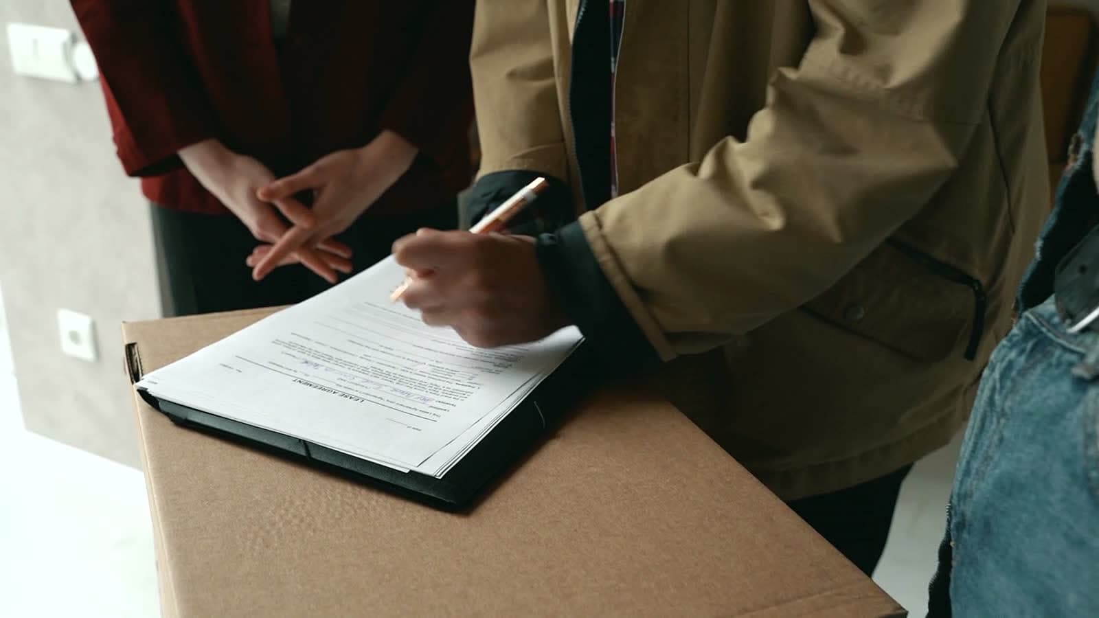 Bureau avec un contrat de bail, un stylo et un trousseau de clés posés sur une table en bois