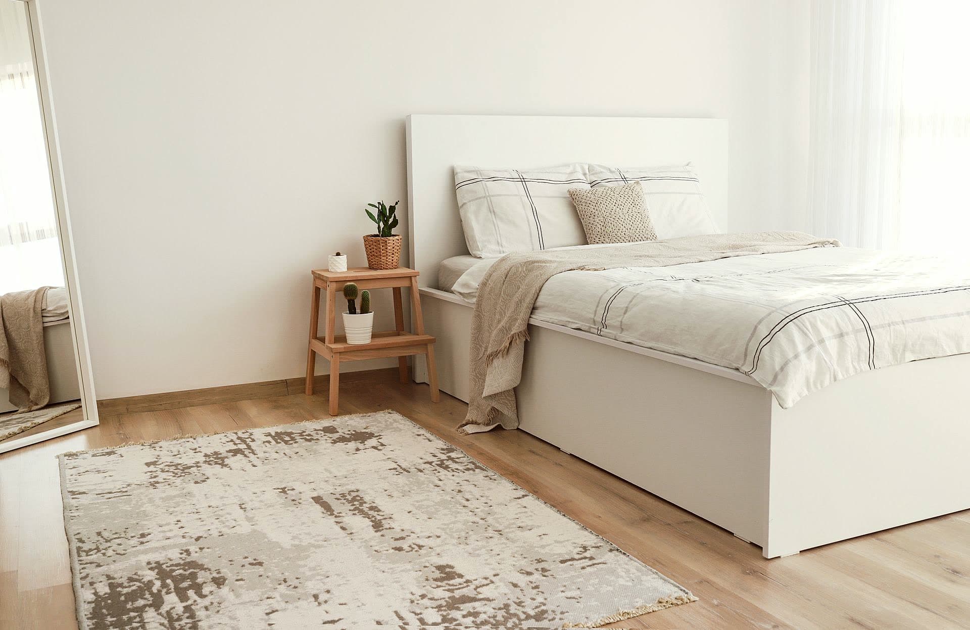 Chambre avec lit fait au carré, literie blanche et chevet en bois